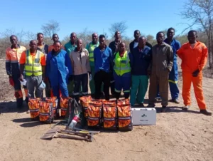 Mapula Maomela standing with her team in front of Sirius business site